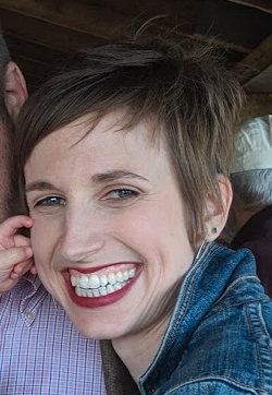 A photo of a smiling women with short, light brown hair.