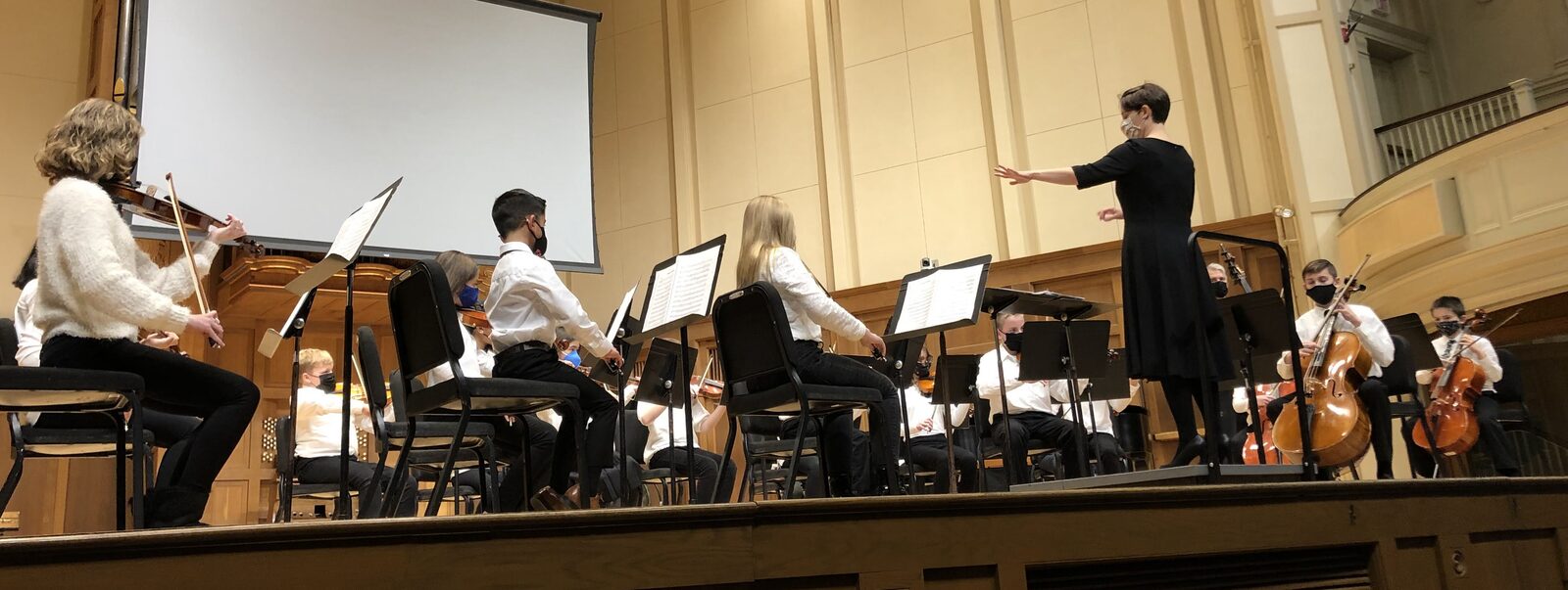 LYSO performs on the Chapel stage during their fall 2021 concert. Mrs. Albright stands in front conducting.