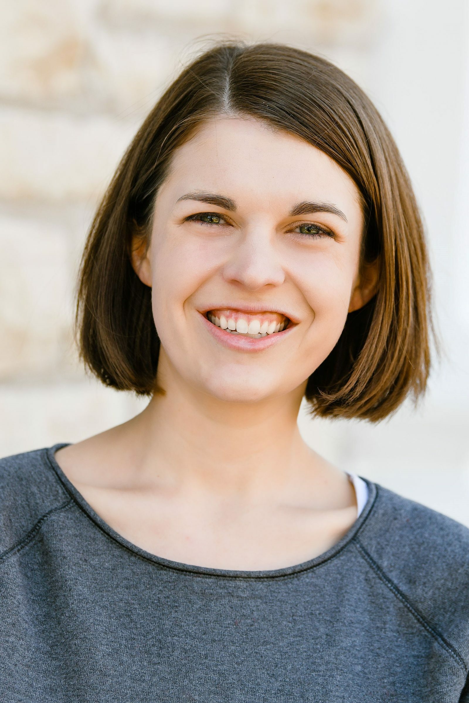 A headshot of a smiling woman with light brown, bobbed hair.