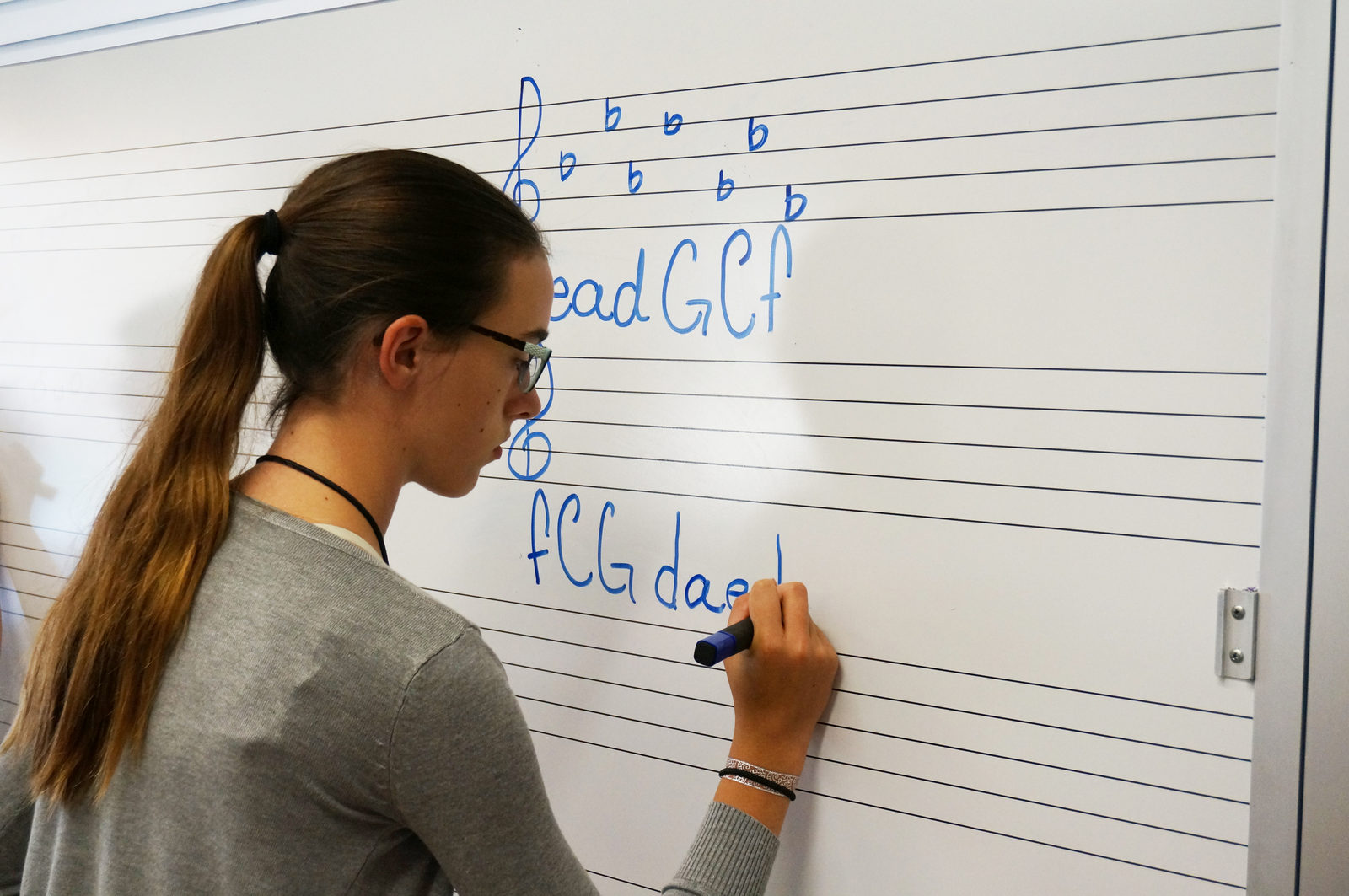 student writing order of flats on white board
